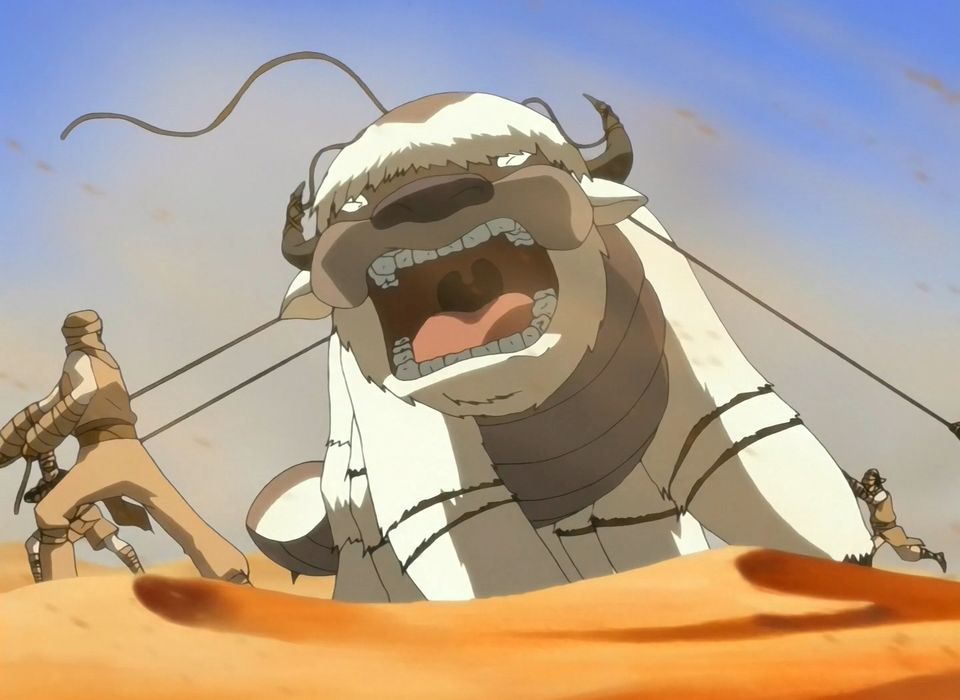 Appa the Sky Bison roars in anger and pain as men attempt to tie him down in a desert