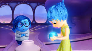 characters from Pixar's film Inside Out showing Sadness with arms crossed looking at Joy who is looking down at the blue sphere she is holding
